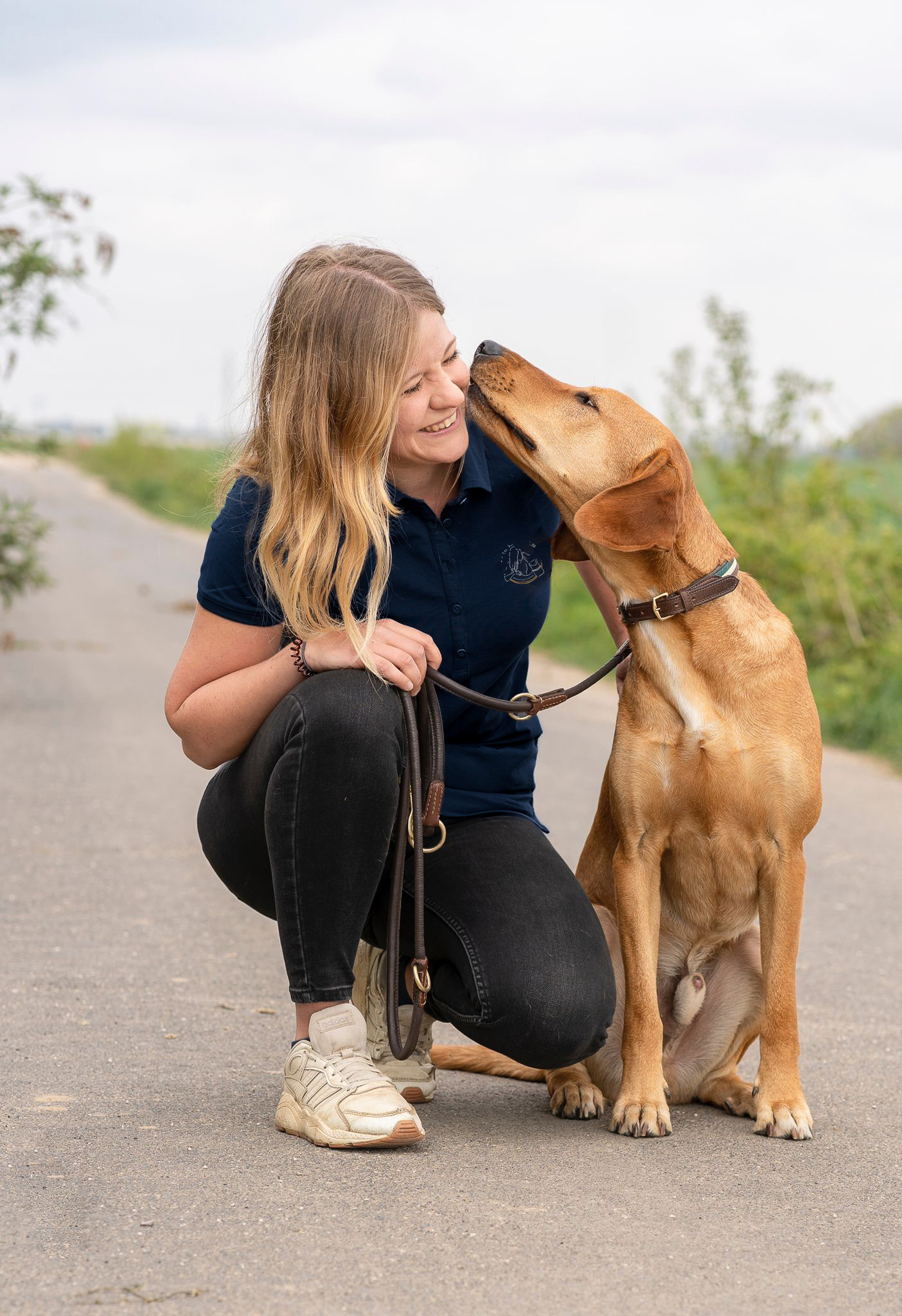 Charlotte wird von ihrem Hund im Gesicht liebkost